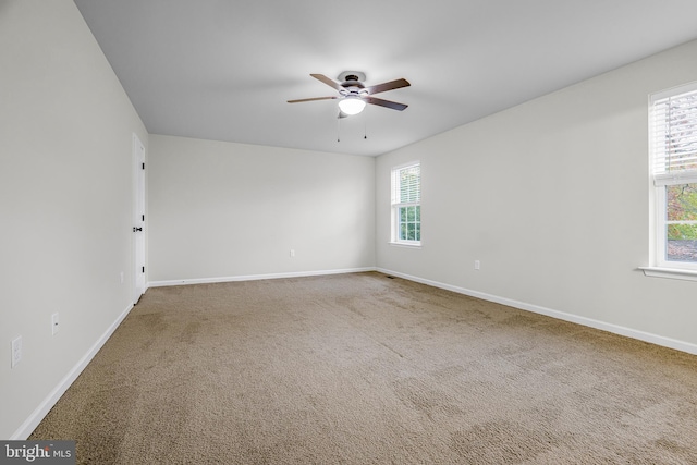 carpeted spare room featuring ceiling fan