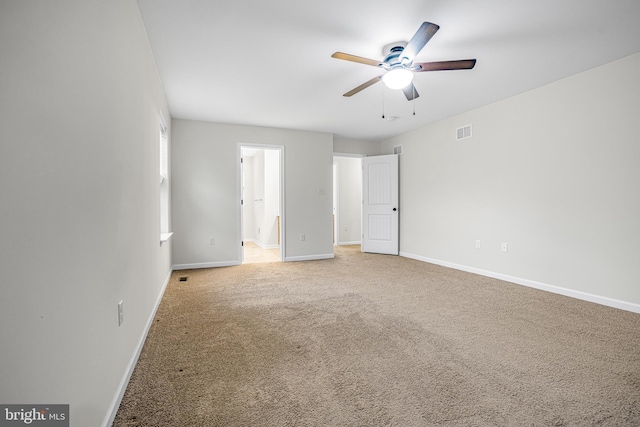 carpeted spare room featuring ceiling fan