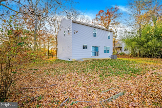 rear view of house featuring a lawn and central air condition unit