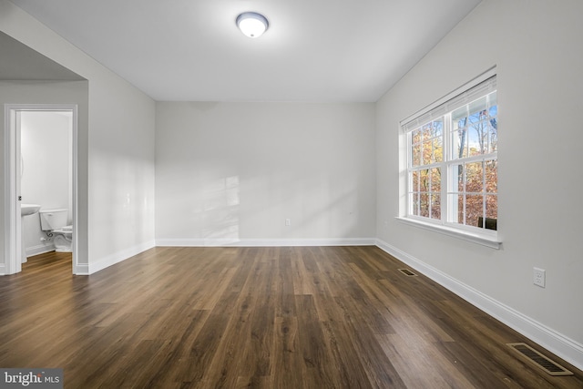 unfurnished room with dark hardwood / wood-style flooring