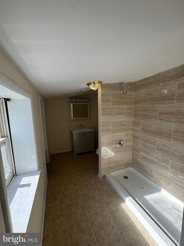 bathroom featuring tile walls, vanity, tile patterned floors, and tiled shower