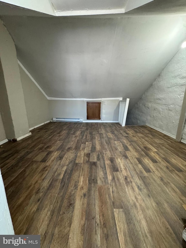 additional living space with dark hardwood / wood-style flooring, vaulted ceiling, and baseboard heating