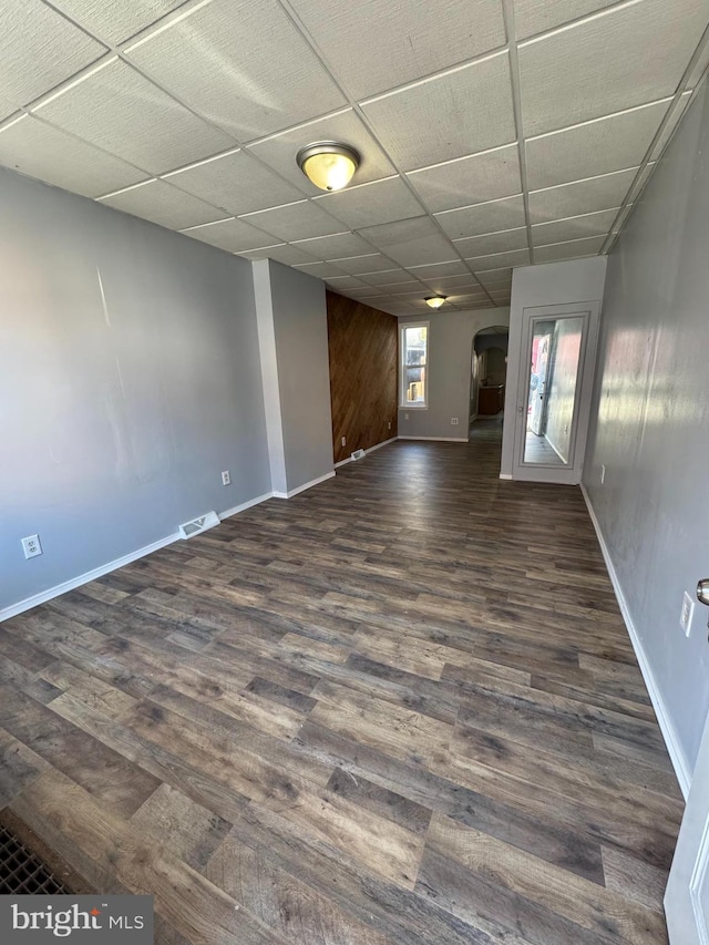 unfurnished room with dark hardwood / wood-style floors and a paneled ceiling