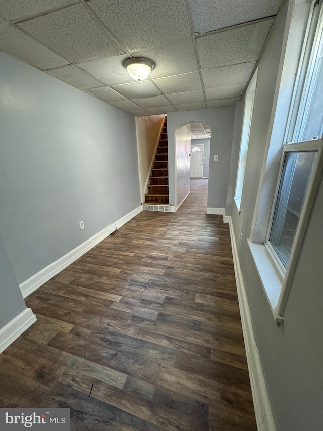 unfurnished room featuring dark hardwood / wood-style flooring and a drop ceiling