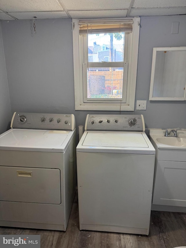 laundry room featuring cabinets, washing machine and dryer, sink, and dark hardwood / wood-style floors