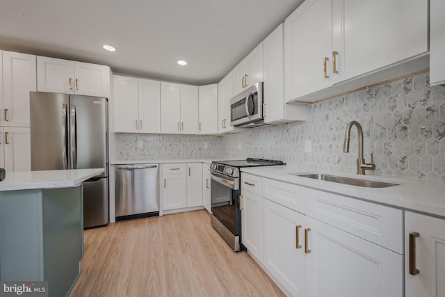 kitchen with decorative backsplash, white cabinets, stainless steel appliances, and light wood-type flooring