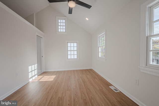 empty room featuring ceiling fan, high vaulted ceiling, and light wood-type flooring