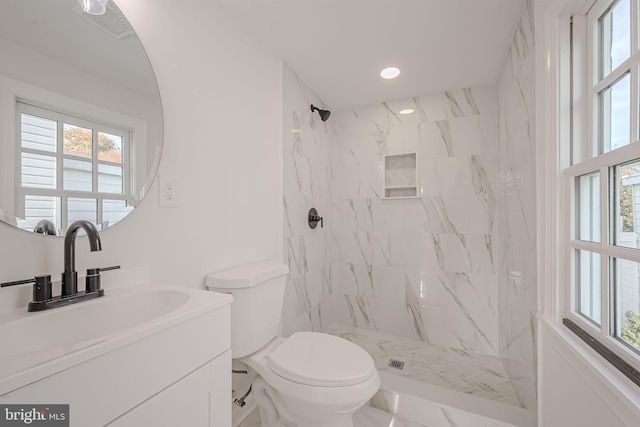 bathroom featuring vanity, toilet, and tiled shower