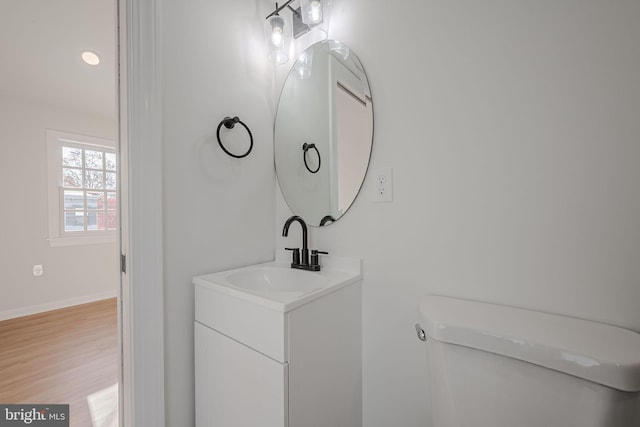 bathroom featuring wood-type flooring, vanity, and toilet