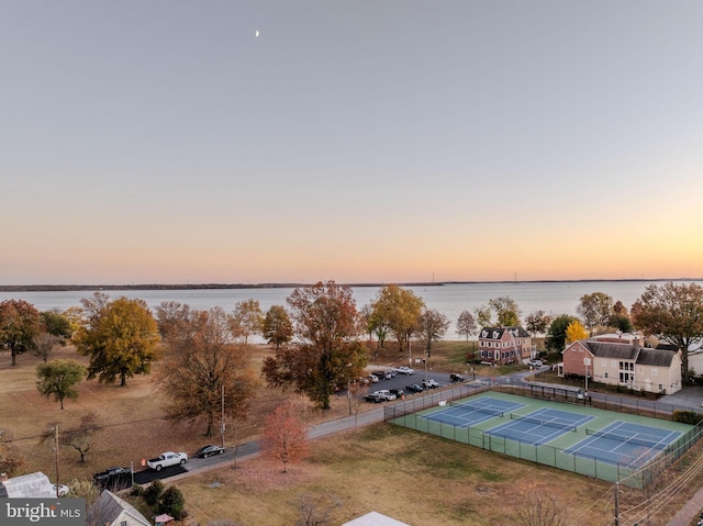 aerial view at dusk featuring a water view