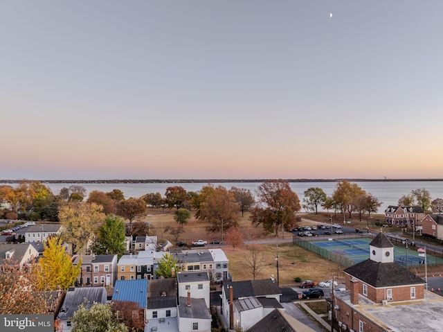 aerial view at dusk featuring a water view