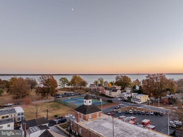 aerial view at dusk featuring a water view