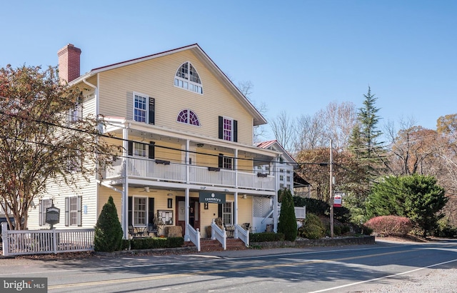 view of property featuring a porch and a balcony