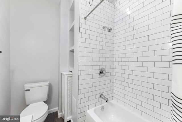 bathroom featuring shower / tub combo and toilet