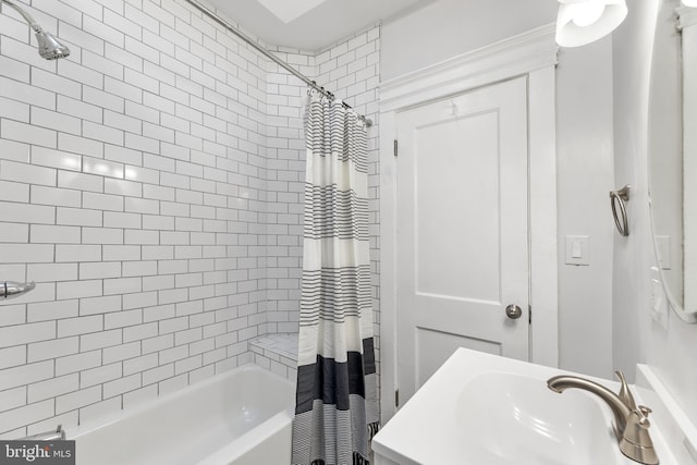 bathroom with shower / bathtub combination with curtain and sink