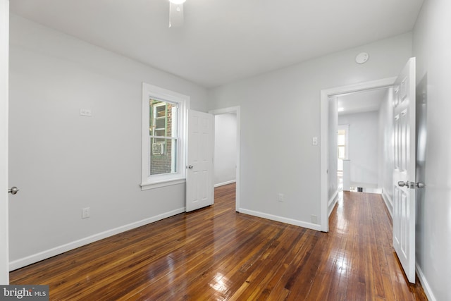 unfurnished bedroom featuring dark hardwood / wood-style floors and multiple windows