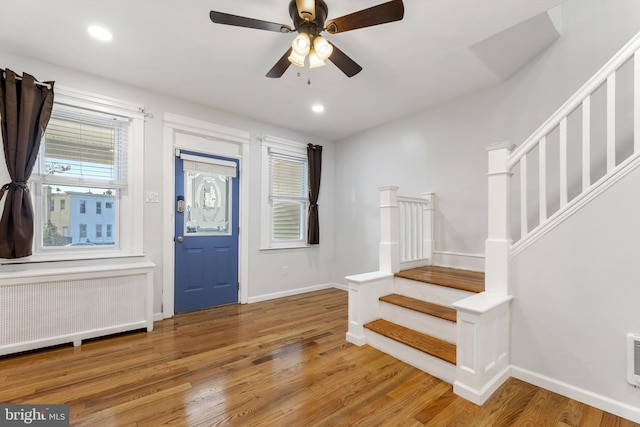 foyer with hardwood / wood-style flooring, ceiling fan, and radiator