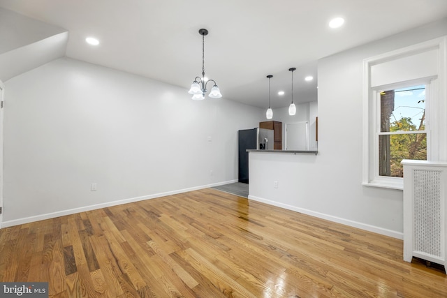 unfurnished living room featuring light hardwood / wood-style floors and a chandelier