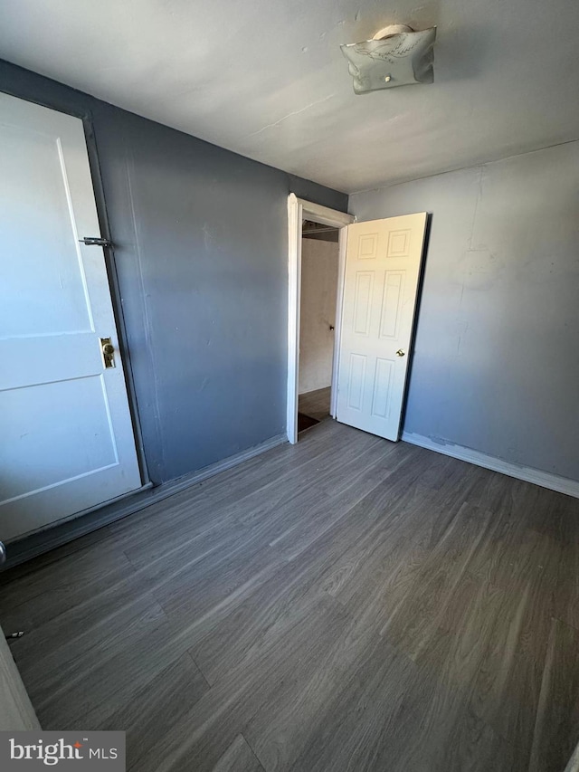 unfurnished bedroom with dark wood-type flooring