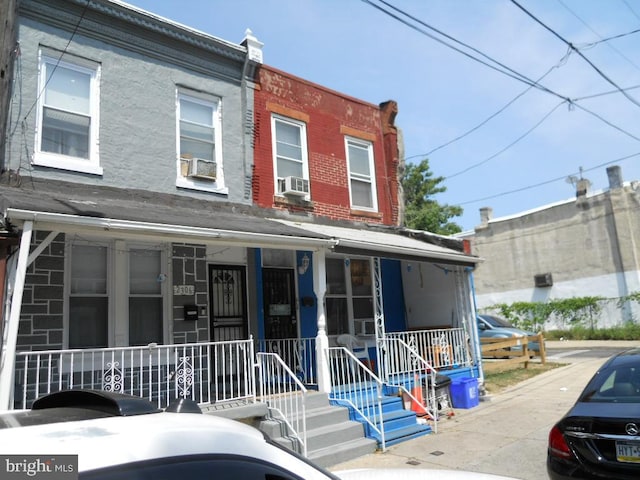 townhome / multi-family property featuring cooling unit and covered porch