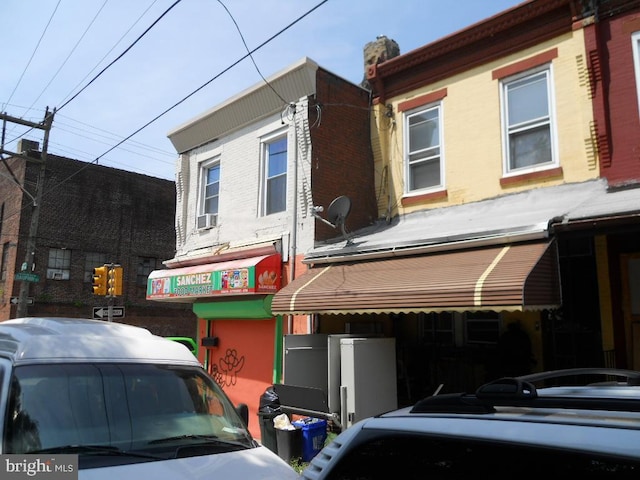 2304 N 25th St, Philadelphia, PA 19132 - view of front facade with cooling unit, a chimney, and brick siding