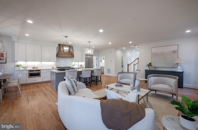 living room featuring light hardwood / wood-style flooring and ornamental molding