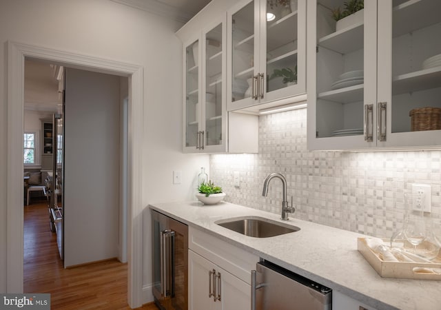 kitchen with hardwood / wood-style floors, sink, wine cooler, light stone counters, and white cabinetry