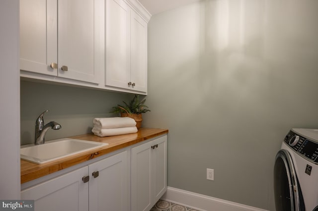 clothes washing area featuring cabinets, separate washer and dryer, and sink