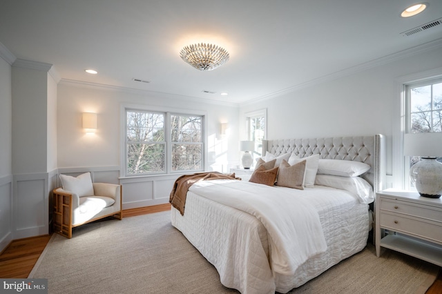 bedroom with light hardwood / wood-style floors and ornamental molding