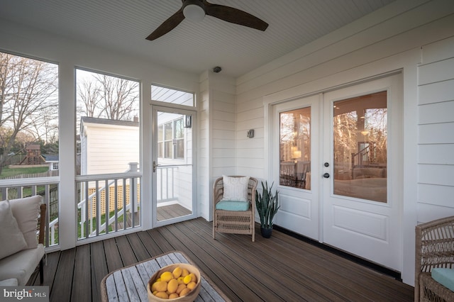 unfurnished sunroom with ceiling fan