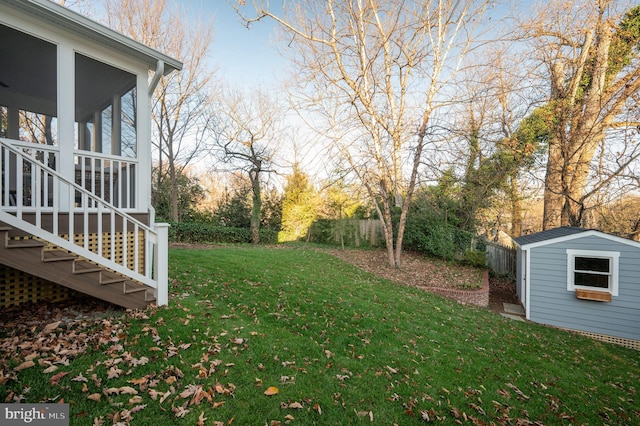 view of yard with a sunroom and a storage shed