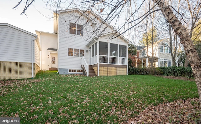 rear view of property with a yard and a sunroom