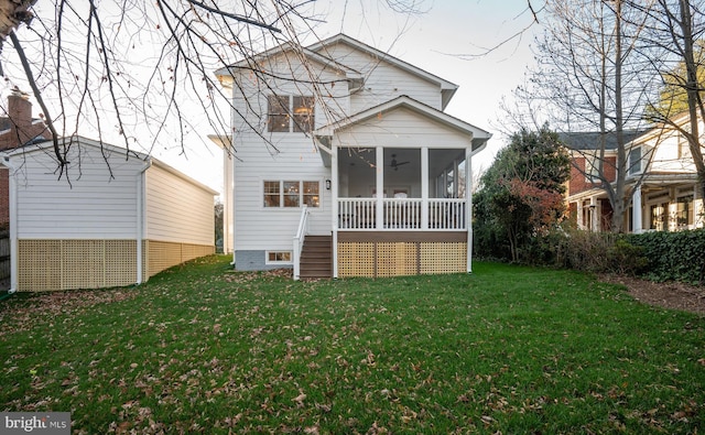 rear view of house with a yard and a sunroom