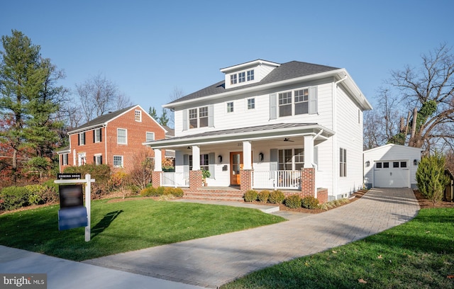 view of front of home with a front yard, covered porch, an outdoor structure, and a garage