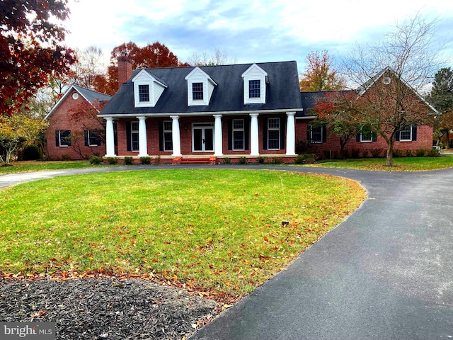 cape cod-style house featuring a front lawn and a porch