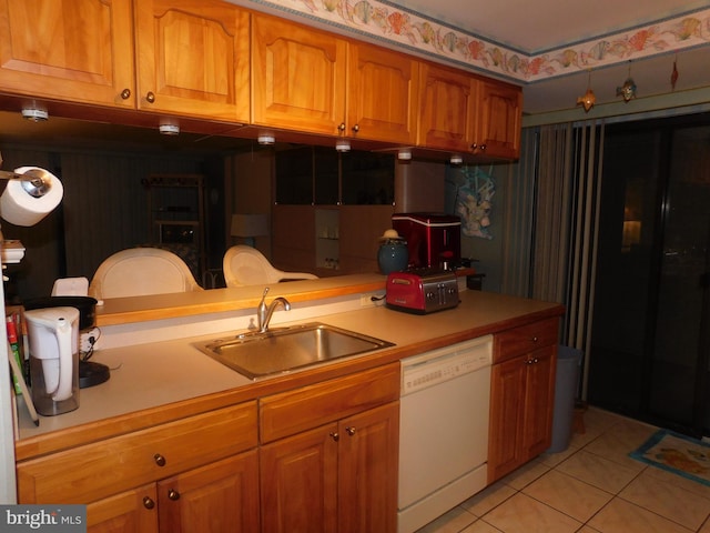 kitchen featuring light tile patterned floors, white dishwasher, and sink