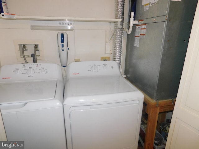 laundry room with washing machine and dryer and heating unit