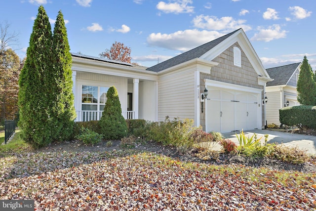 view of side of home with a garage and covered porch