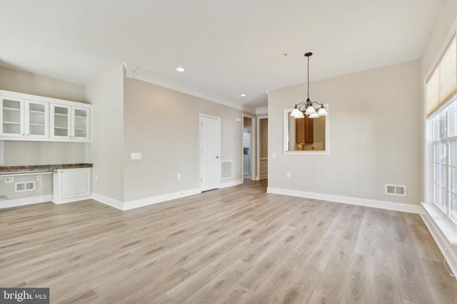 interior space with ornamental molding, light hardwood / wood-style flooring, and an inviting chandelier