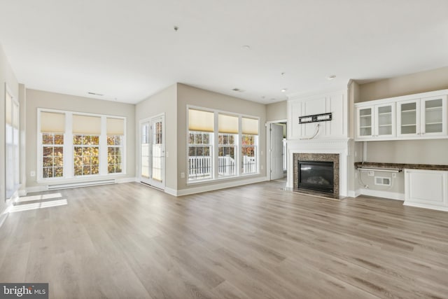 unfurnished living room featuring a fireplace and light hardwood / wood-style floors