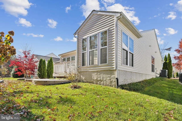 view of property exterior featuring central AC and a yard