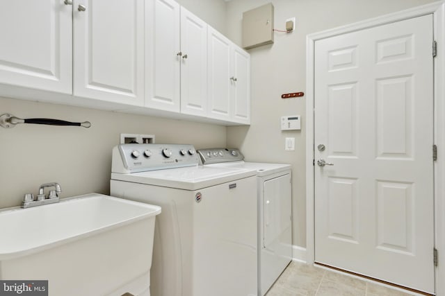 laundry room with cabinets, washing machine and dryer, sink, and light tile patterned flooring