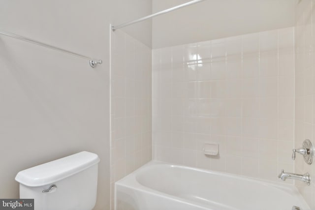 bathroom featuring toilet and tiled shower / bath