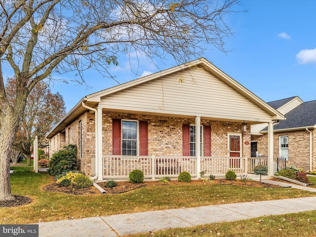 view of front of property featuring covered porch and a front yard