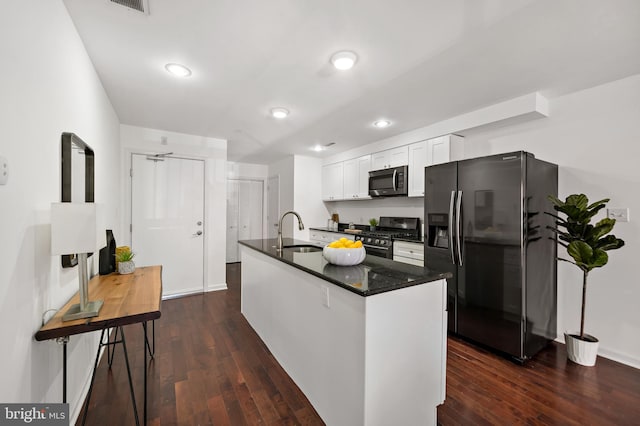 kitchen with dark wood-type flooring, appliances with stainless steel finishes, sink, and white cabinets