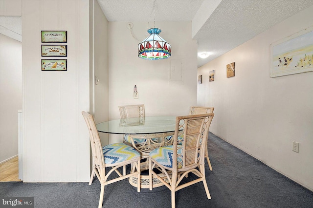 carpeted dining room featuring a textured ceiling