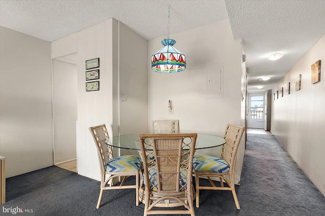 dining room with electric panel, a textured ceiling, and dark colored carpet