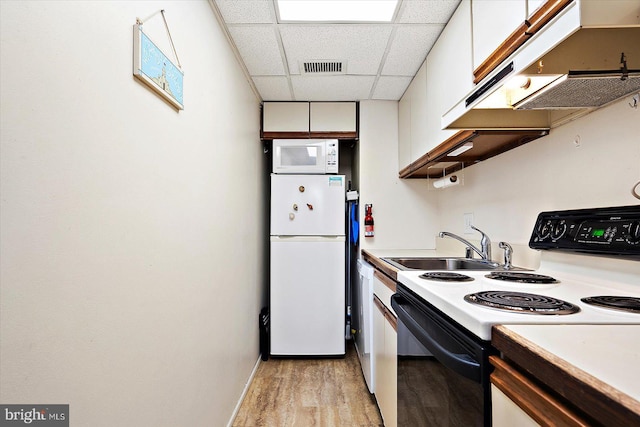 kitchen featuring light hardwood / wood-style flooring, a paneled ceiling, white appliances, and white cabinets