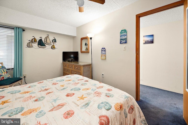 carpeted bedroom featuring ceiling fan and a textured ceiling