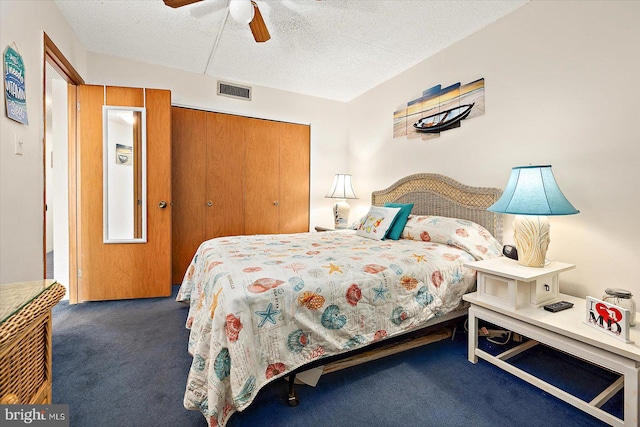 carpeted bedroom featuring ceiling fan, a textured ceiling, and a closet